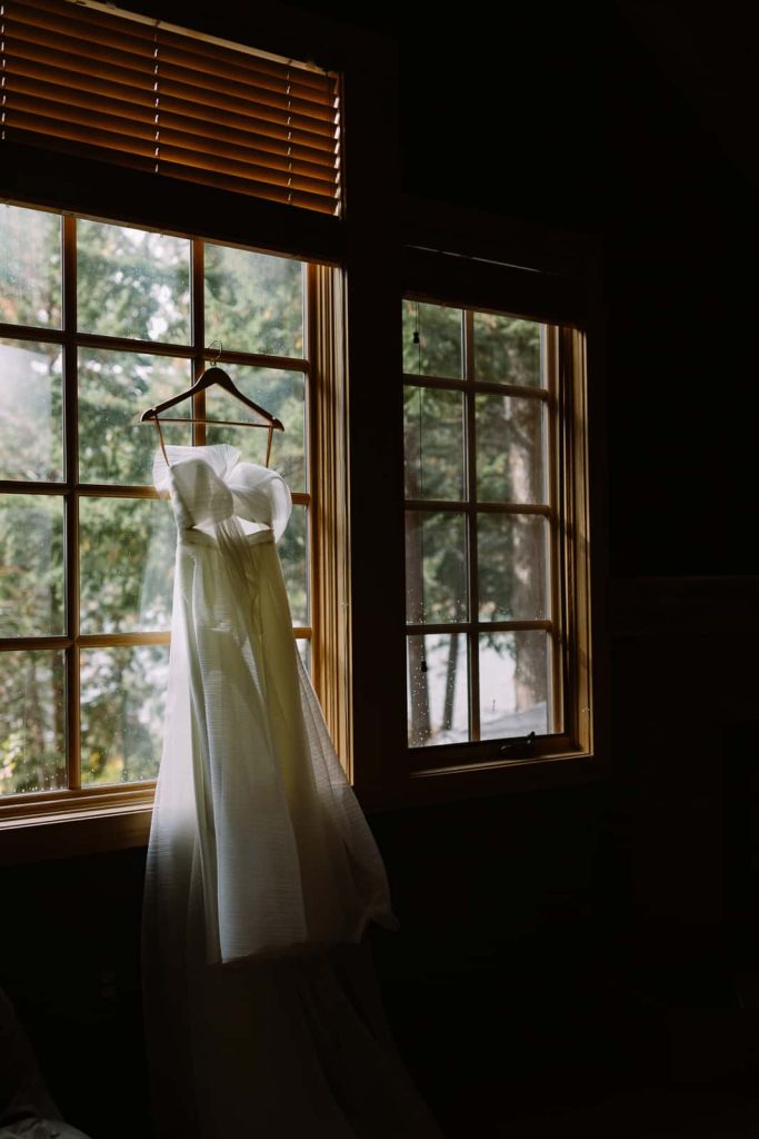 wedding dress hanging in a window.