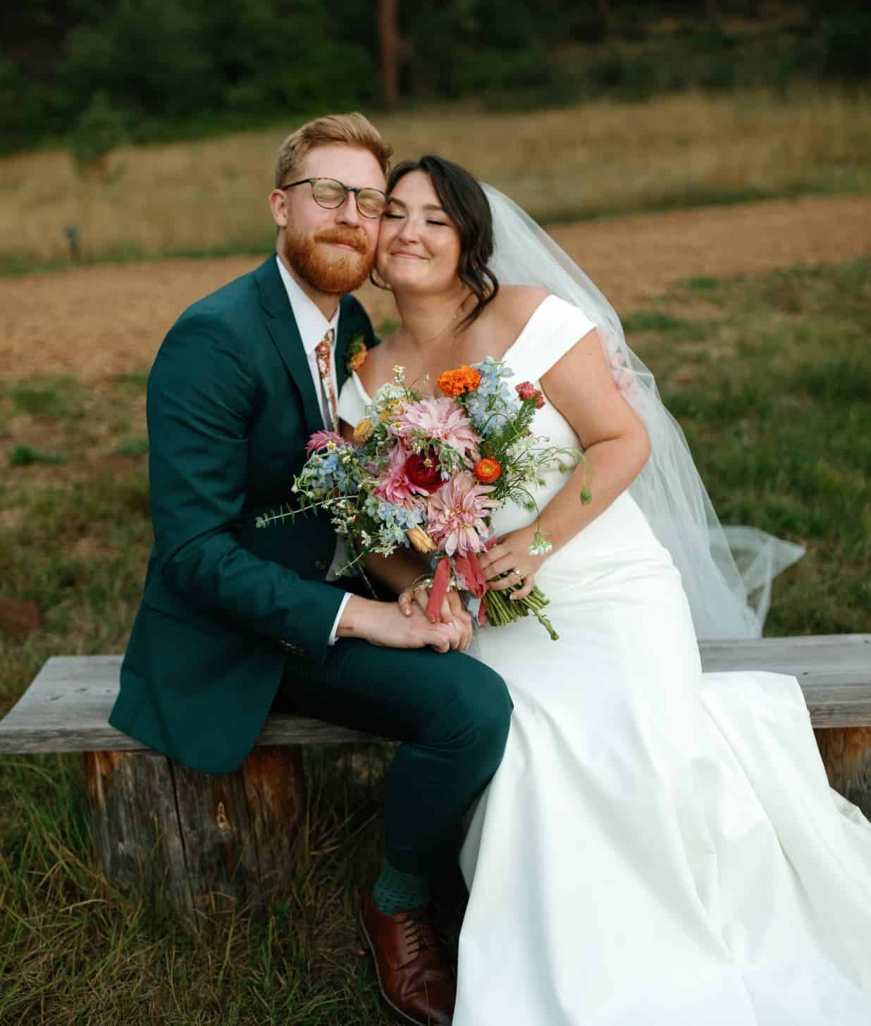 a couple sitting on a bench relaxing and closing their eyes after getting married in central oregon