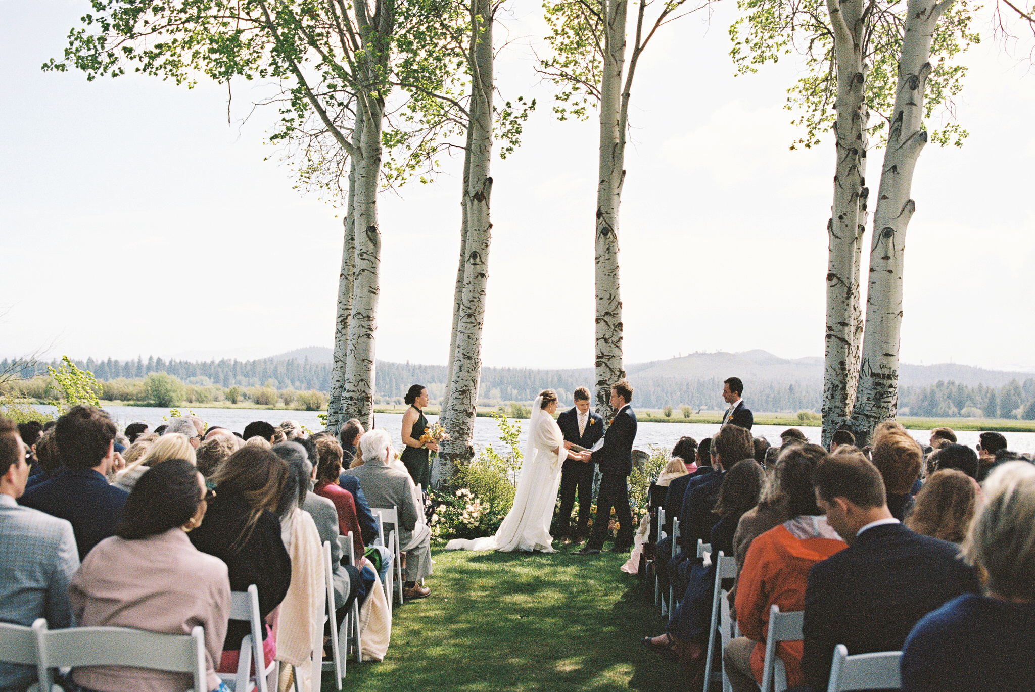 wedding ceremony with a couple holding hands and ponderosa trees behind them