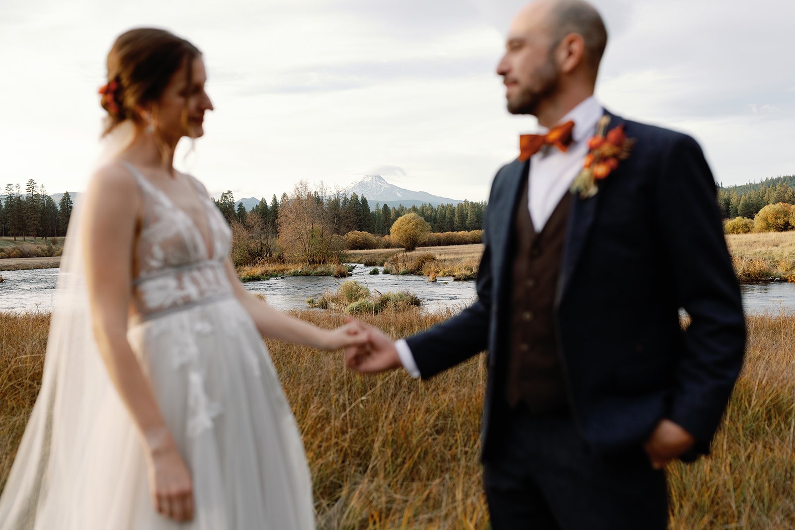 the bride and groom posing in the outdoor area of a central oregon wedding venues at house on metolius