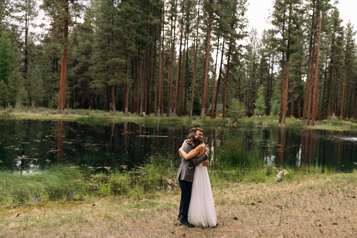 the bride and groom sharing a hug at lake creek lodge outdoor wedding in central oregon