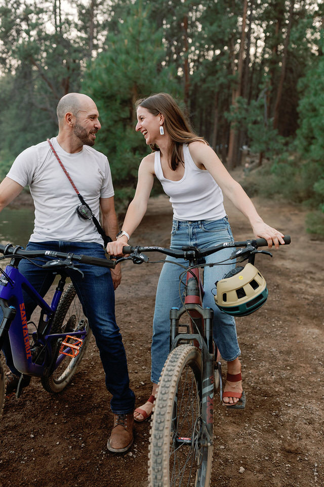 couple sitting on bikes and laughing while looking at each other