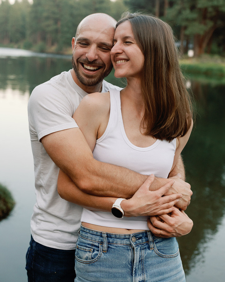 couple hugging each other while closing their eyes and laughing
